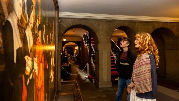 Visitors looking at Sir Thomas More and his Family painting by Hans Holbein the Younger at Nostell, West Yorkshire